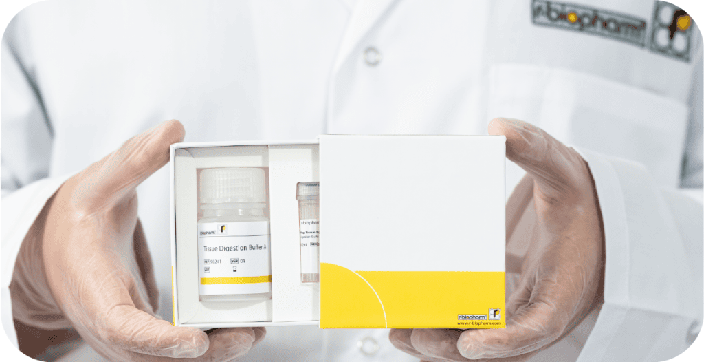 a man in a lab coat holds a box containing the RIDA®Prep Tissue Digestion Kit